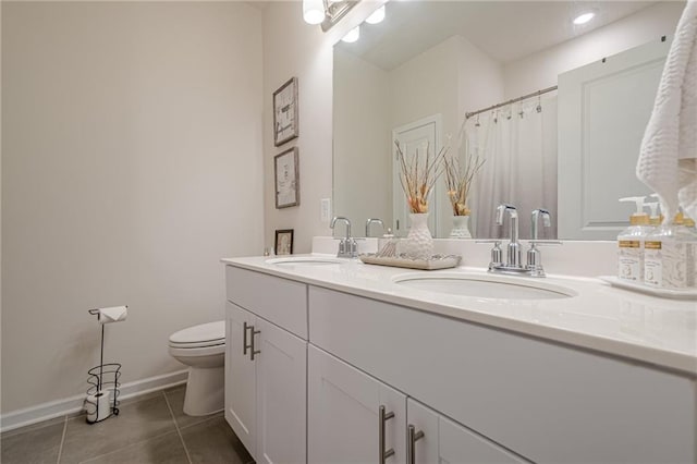 bathroom with tile patterned flooring, toilet, baseboards, and double vanity