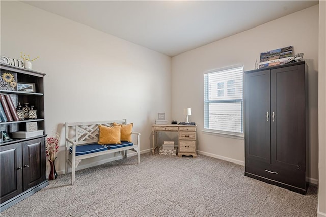 sitting room featuring light colored carpet and baseboards