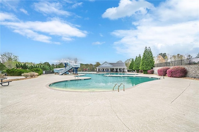 community pool with fence and a patio area