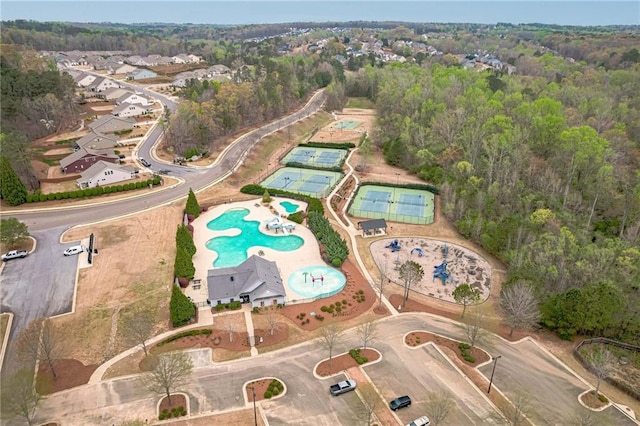 aerial view of property's location featuring a pool area and a heavily wooded area