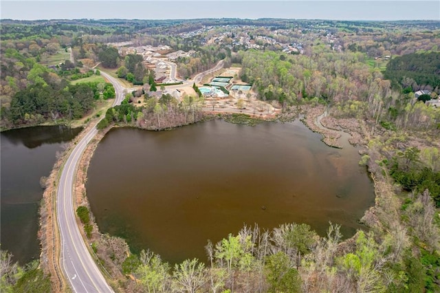 view of property location featuring a nearby body of water and a forest
