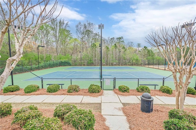 view of tennis court featuring fence and a gate