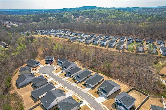 view of property location featuring nearby suburban area and a forest