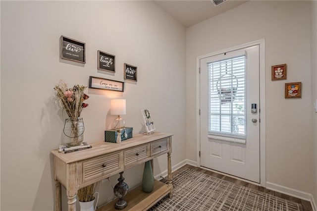 doorway featuring baseboards and healthy amount of natural light