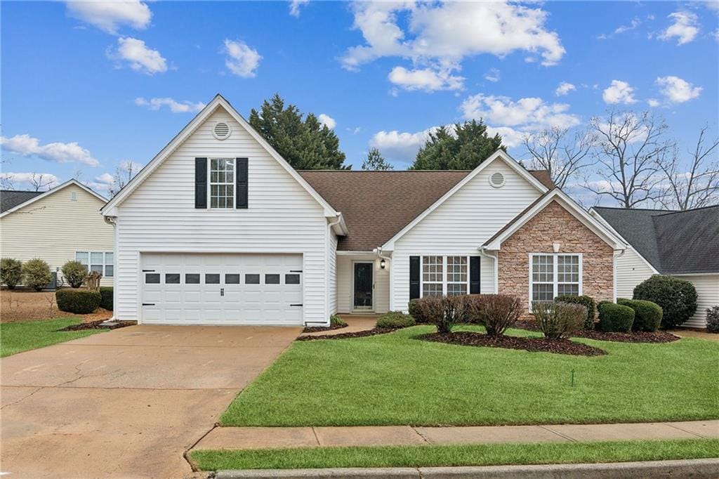 view of property featuring a garage and a front yard