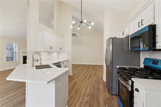 kitchen with sink, white cabinetry, kitchen peninsula, stainless steel appliances, and light hardwood / wood-style floors