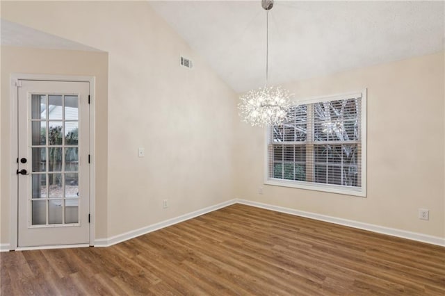 unfurnished dining area with an inviting chandelier, hardwood / wood-style floors, and vaulted ceiling