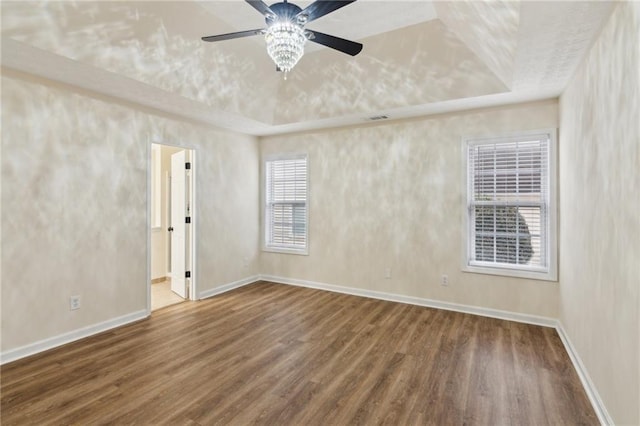 spare room featuring hardwood / wood-style flooring, ceiling fan, and a tray ceiling