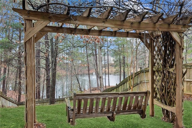 wooden terrace with a yard and a water view