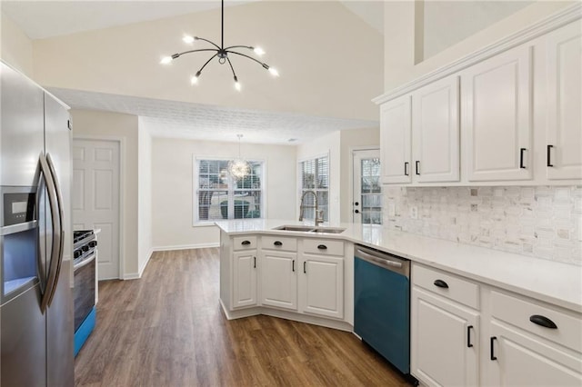 kitchen with sink, decorative light fixtures, stainless steel appliances, and white cabinets