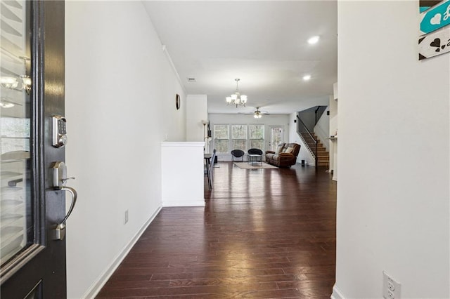 entryway with baseboards, wood finished floors, stairs, and ceiling fan with notable chandelier