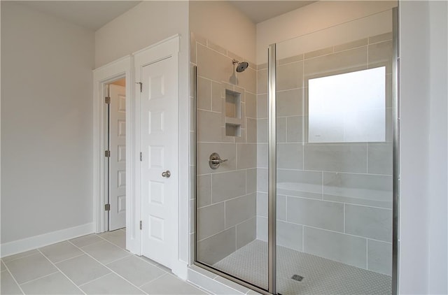 full bathroom with a stall shower, baseboards, and tile patterned floors