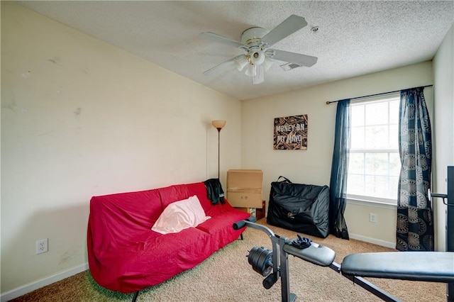 living area featuring a textured ceiling, ceiling fan, carpet flooring, visible vents, and baseboards