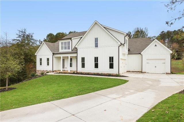 modern farmhouse with covered porch, a garage, and a front lawn