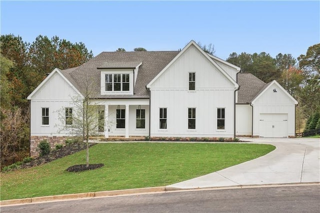 modern farmhouse style home with a front yard and a garage