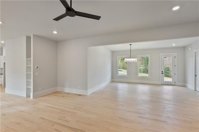 unfurnished living room with a wealth of natural light, ceiling fan, and light hardwood / wood-style floors