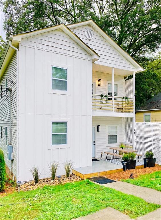 view of front of home with a balcony and a front lawn