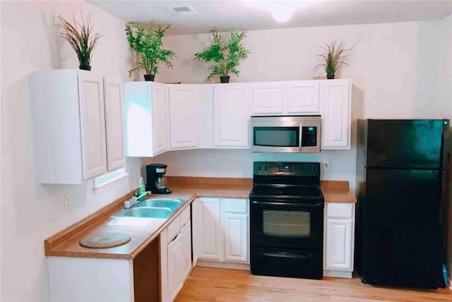 kitchen featuring white cabinetry, sink, light hardwood / wood-style flooring, and black appliances