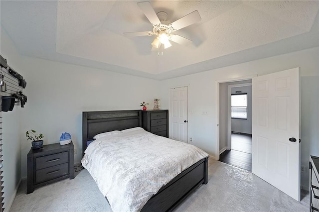 bedroom featuring a ceiling fan and a tray ceiling