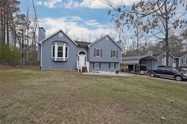 view of front of home featuring entry steps, a detached carport, fence, and a front lawn