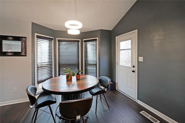 dining room with visible vents, baseboards, lofted ceiling, and dark wood-style flooring