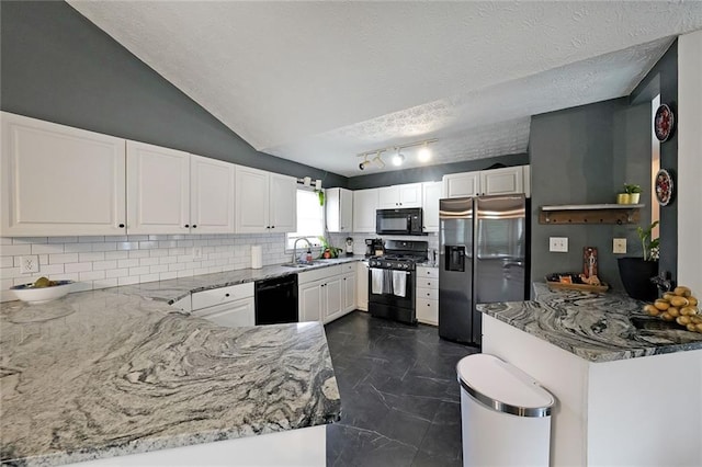 kitchen featuring a sink, light stone counters, black appliances, and white cabinetry