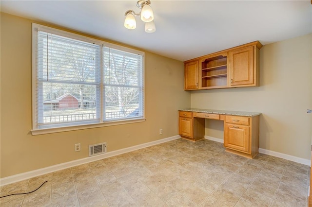 unfurnished office with plenty of natural light and an inviting chandelier