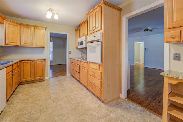 kitchen featuring light stone countertops, white appliances, light hardwood / wood-style flooring, and ceiling fan