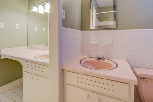 bathroom featuring walk in shower, vanity, toilet, and tile walls