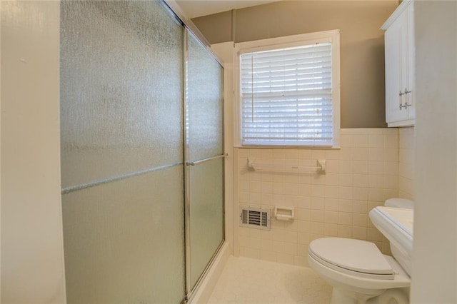 bathroom featuring toilet, tile walls, and walk in shower