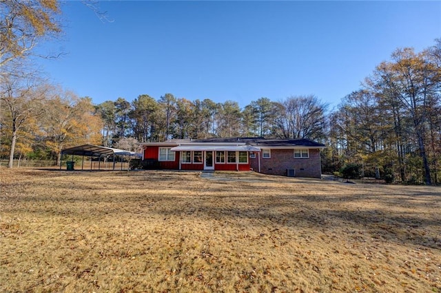 view of front of home featuring a carport, a sunroom, and a front yard