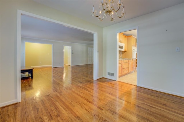 interior space featuring a notable chandelier and light wood-type flooring