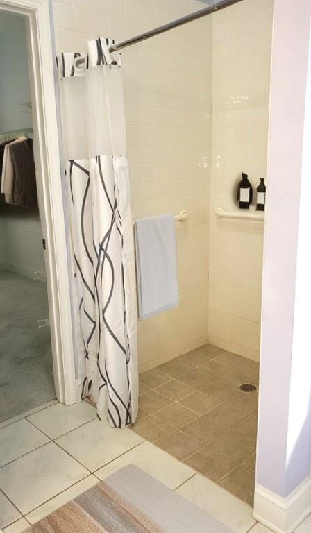 bathroom with tile patterned floors, tile walls, and tiled shower