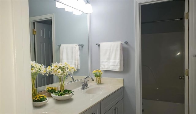 full bath featuring double vanity, walk in shower, and a sink