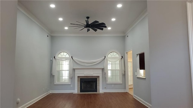 unfurnished living room featuring crown molding, hardwood / wood-style flooring, a tile fireplace, and ceiling fan