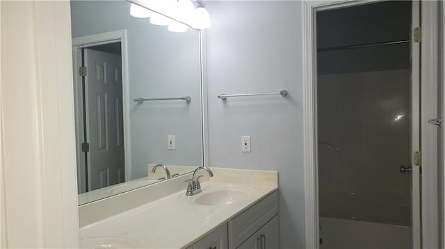bathroom with double vanity, a shower, and a sink