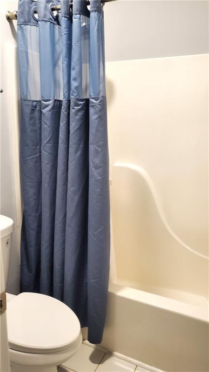 full bath with toilet and shower / bath combination with curtain