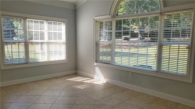 unfurnished dining area with ornamental molding, tile patterned flooring, and baseboards