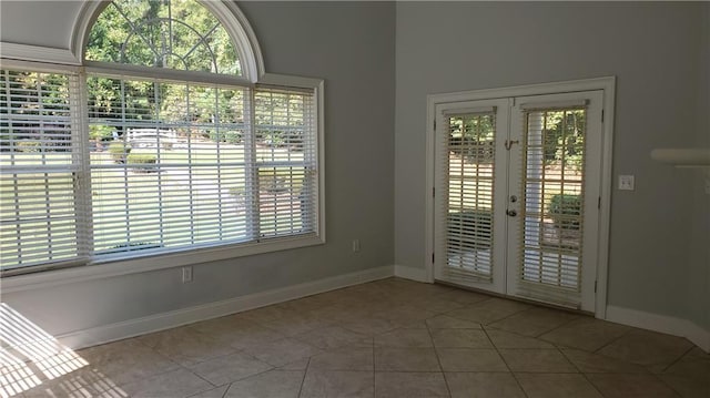 interior space with tile patterned floors, french doors, and baseboards