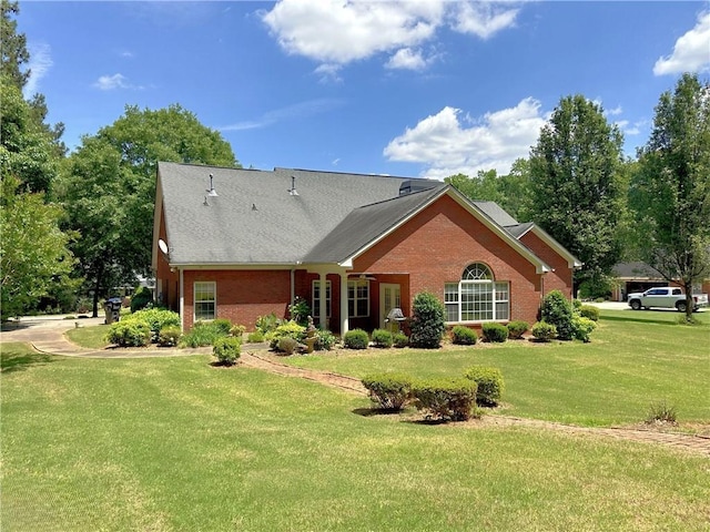 exterior space featuring brick siding and a yard
