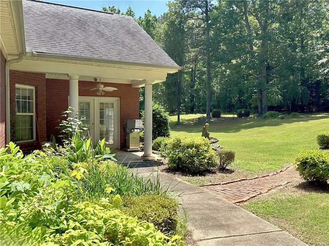 view of yard with french doors and ceiling fan