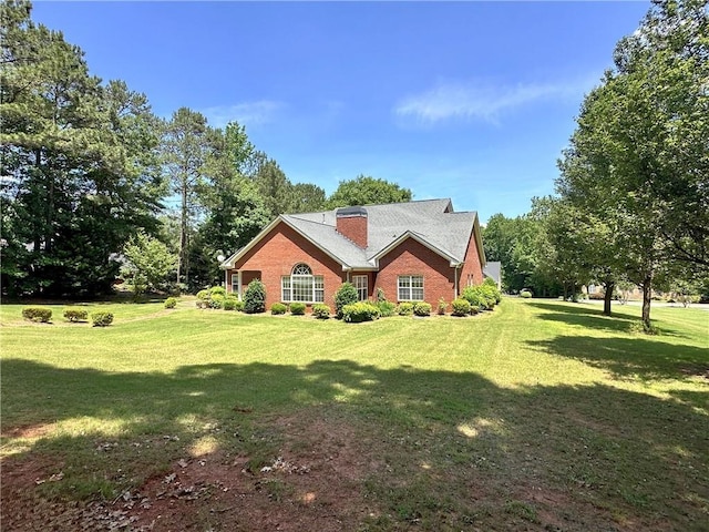 view of property exterior featuring brick siding and a yard