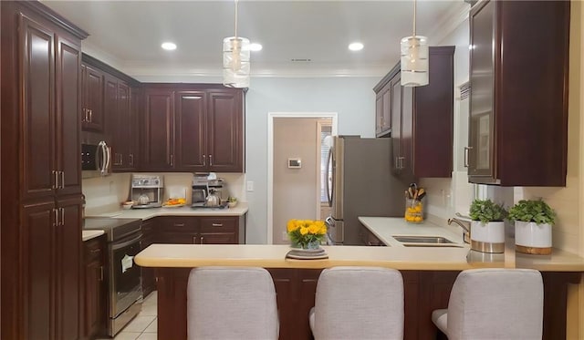 kitchen with ornamental molding, a peninsula, appliances with stainless steel finishes, and light countertops