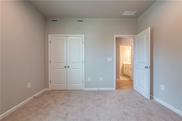 unfurnished bedroom featuring light carpet