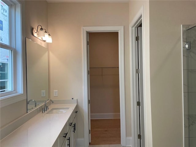 bathroom with tile patterned flooring, vanity, and walk in shower