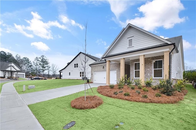 view of front of property featuring brick siding, a porch, a garage, driveway, and a front lawn