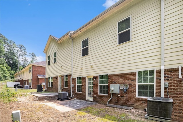 876 Ivydale Ln Unit 63, Lawrenceville, GA 30045 - rear view of house with cooling unit, a patio area, and brick siding