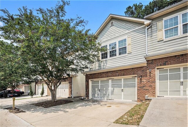 876 Ivydale Ln Unit 63, Lawrenceville, GA 30045 - townhome / multi-family property with a garage, driveway, and brick siding