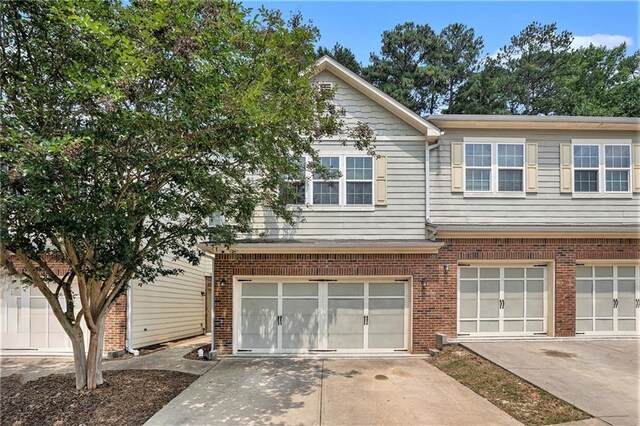 876 Ivydale Ln Unit 63, Lawrenceville, GA 30045 - multi unit property featuring an attached garage, concrete driveway, and brick siding