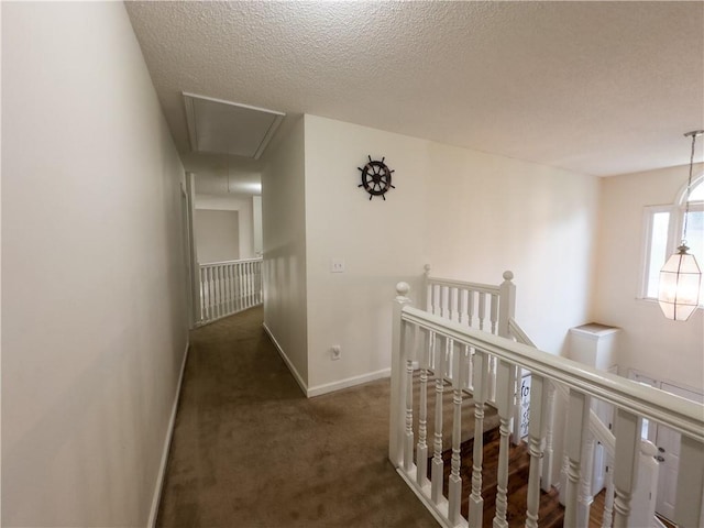 111 Bexley Ln, Douglasville, GA 30134 - hallway featuring attic access, an upstairs landing, carpet flooring, baseboards, and a textured ceiling